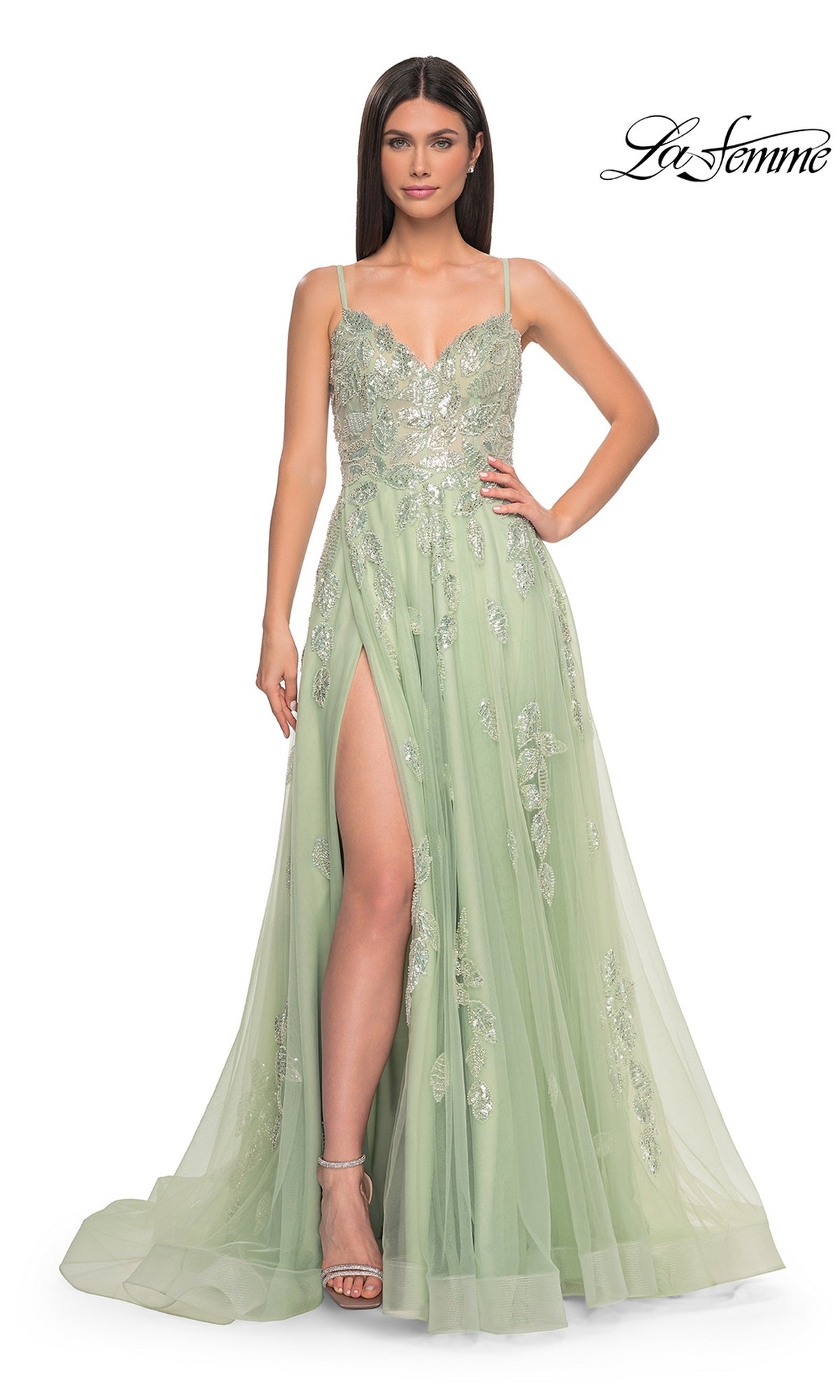 A woman wears the La Femme Sequin-Embroidered Long Prom Dress 32090 in light green, featuring thin straps, a sweetheart neckline, sequin embroidery, and a high slit as she stands against a white background.